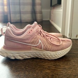 Pink Nike react women’s shoes.